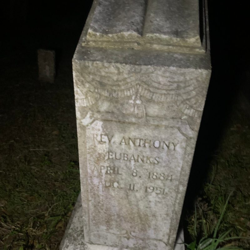 a gravestone in front of a stone building