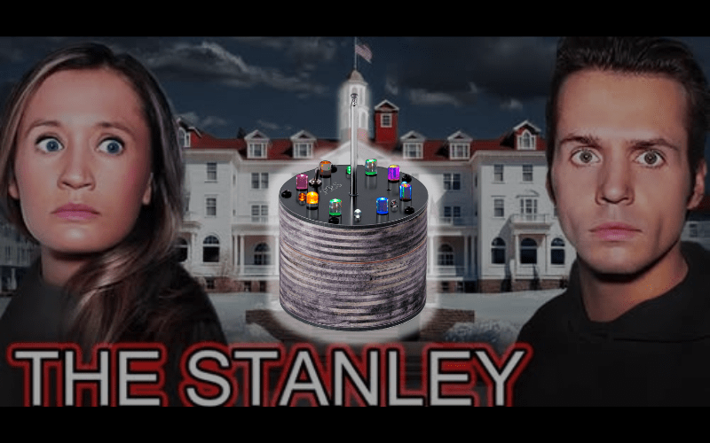 Two people look surprised; a cylindrical device overlays a hotel background, 'The Stanley' text below.